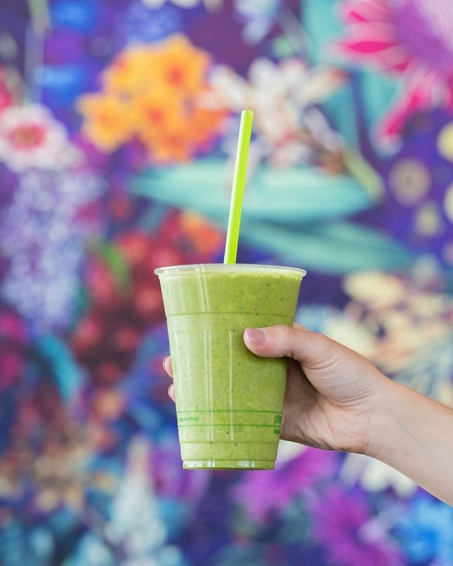 Fresh cold-pressed green juice in a to-go cup